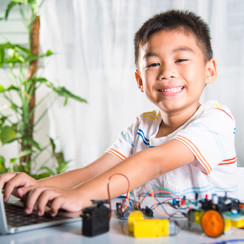 Kid smiling and working on a computer